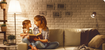Mother and daughter reading on the couch in a modern home